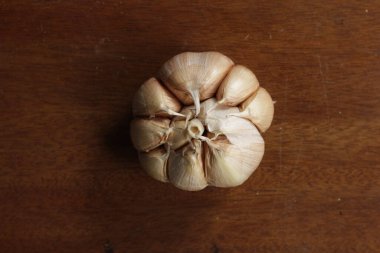 Sarımsak ahşap arka planda izole edilmiş. Sarımsak tüketimi kan basıncının düşmesine ve kemik sağlığının iyileşmesine yardımcı olabilir..