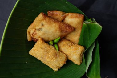 Fried food isolated on a black background. Fried foods are a popular snack. Fried food vendors can be found on the side of the road or around on a pole or cart. The ingredients are floured and fried. Blurred focus.