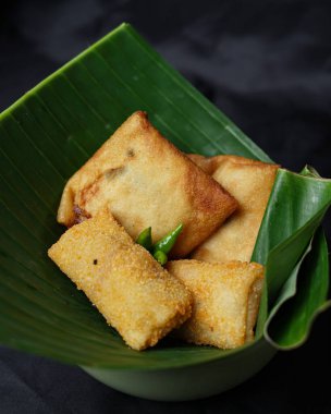 Fried food isolated on a black background. Fried foods are a popular snack. Fried food vendors can be found on the side of the road or around on a pole or cart. The ingredients are floured and fried. Blurred focus.
