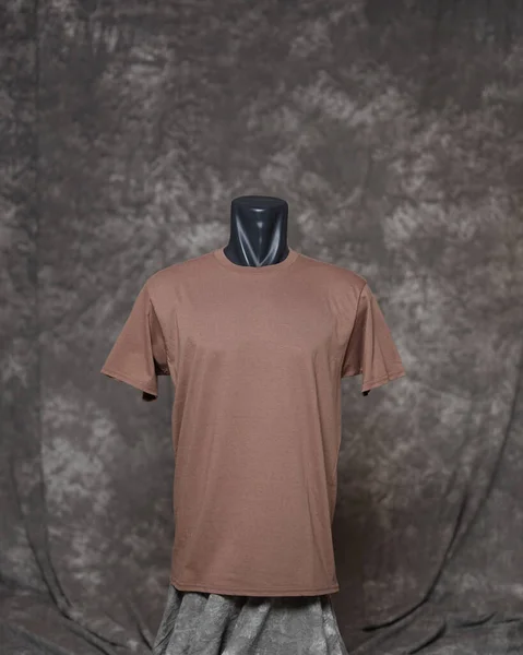 Men\'s brown blank t shirt template, from front side, natural shape on invisible mannequin, for your design mockup for printing, isolated on motif gray background. Free space for your ad.