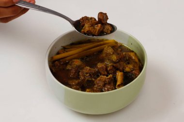 Rawon ineği beyaz arka planda izole edilmiş. Rawon, Endonezya usulü, özel baharat karışımı kluwek kullanan bir kara et çorbası türüdür. Rawon 'un eti genellikle sığır etidir. yemek modeli.