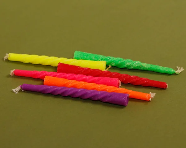 Assorted-color candles isolated on green background. This candle is usually used for decoration on cakes to celebrate an event. Mini candle mockup.