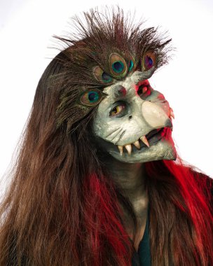 Jember, East Java  Indonesia - August 12, 2021: A woman wearing a peacock head mask with a spooky look in Jember City, East Java.