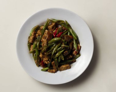 Kızarmış nohut ve tempeh, beyaz bir tabakta baharatla karıştırılmış. Bu yiyecekler öğle yemeği menüsü olarak kullanılabilir. Kızarmış nohut maketi.