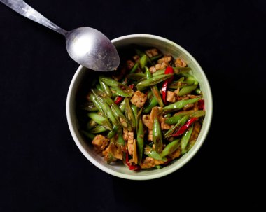 Kızarmış nohut ve tempeh yeşil bir tabakta baharatla karıştırılmış. Bu yiyecekler öğle yemeği menüsü olarak kullanılabilir. Kızarmış nohut maketi.