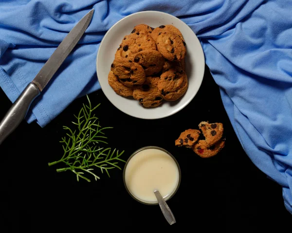 Chocolate biscuits with chocolate chip topping as snacks in the morning, are very popular among children to old age. Biscuits and milk are the perfect combination of food and drink. Biscuit mockup. Focus blur.