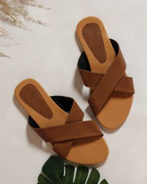 Kadın sandaletleri, açık ve koyu kahverengiyle basit ve zarif bir tasarımın karışımıdır. Günlük kullanım için rahat sandaletler. Haihil olmayan sandaletler. Marka reklamın için boş bir yer. Sandalet maketi. Odak bulanıklığı.