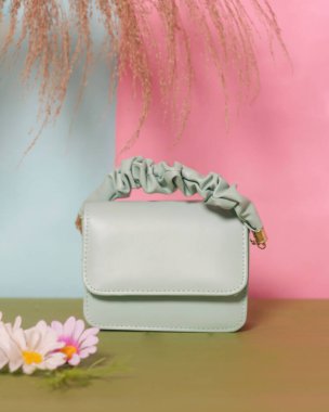 Pastel yeşil kadın çantası zarif bir izlenim yaratıyor. Resmi etkinliklere katılmak ya da aile ve arkadaşlarla takılmak için çok uygun. Basit bir tasarımı olan bir çanta. Çanta modeli..