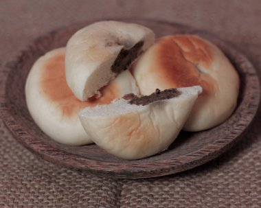 Bakpia kek modeli. Bakpia çeşitli dolgularla pişirilmiş öğütülmüş undan oluşur. Çikolata dolu Bakpia, sabahları kahvaltı menüsü ya da gün içinde atıştırmalık olarak tüketilmeye uygundur. Odak bulanıklığı.