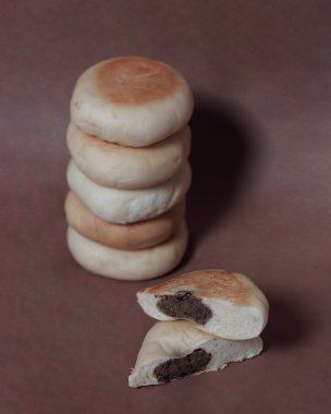 Bakpia kek modeli. Bakpia çeşitli dolgularla pişirilmiş öğütülmüş undan oluşur. Çikolata dolu Bakpia, sabahları kahvaltı menüsü ya da gün içinde atıştırmalık olarak tüketilmeye uygundur. Odak bulanıklığı.