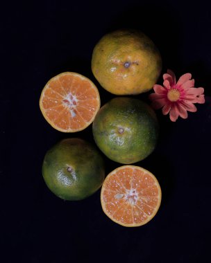 Parlak taze portakallar. Taze portakalları parlak bir arka planla birleştirme kavramı genellikle tasarım şablonları ve modellemeler için kullanılır. Güzel bir portakal dilimi. Odak bulanıklığı.