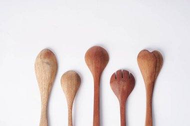 Tahta kaşıklar beyaz arkaplana karşı sıralanır                        