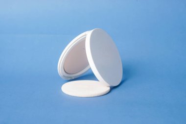 Bir yüz pudrası mavi arkaplana güzelce yerleştirilir.                           