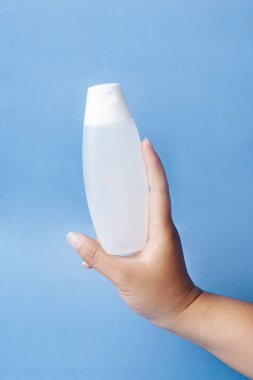 Bir Viva Air Mawar şişesi mavi arka planda nazikçe elle tutulur.                               