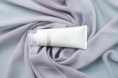 Bir yüz sabunu yumuşak gri bir kumaşa nazikçe dayanır.                             