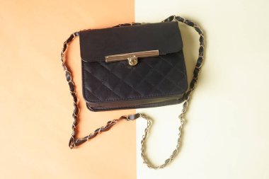     Siyah bir çanta turuncu ve krem arka planda sergilenir