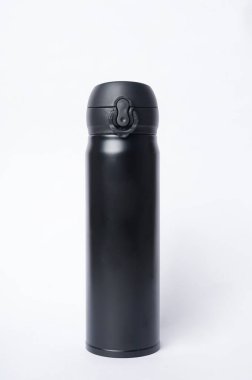 Siyah bir içki şişesi temiz beyaz bir arka plana yerleştirilir.