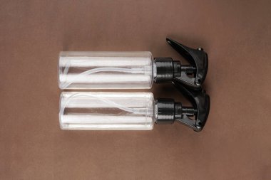 Kahverengi arka plana iki oda spreyi konur, sıcak ve dünyevi bir sunum oluşturur.                      