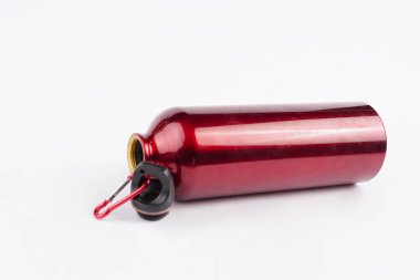 Kırmızı içki şişesi temiz beyaz arka plana yerleştiriliyor ve çarpıcı bir kontrast oluşturuyor.   