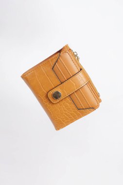 Kahverengi cüzdan temiz beyaz bir arkaplana yerleştirilir, basit ve zarif bir görünüm yaratır.                               