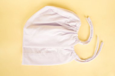 Ciput düzgün bir şekilde parlak sarı bir arka plana yerleştirilir, sıcak ve neşeli bir sunum oluşturur.                     