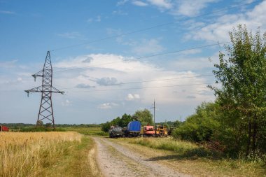 Stara Vyzhivka, Ukrayna - 20 Haziran 2019: Kamyon ve inşaat ekipmanları toprak yolun kenarında