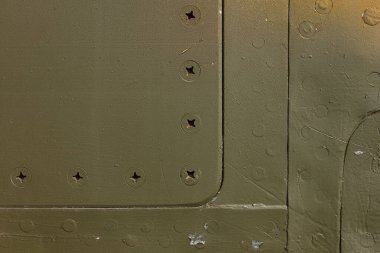 Eski bir uçağın gövdesinin detayları. Askeri bir uçağın üzerinde boya ve perçin ile kamuflaj yüzeyi.