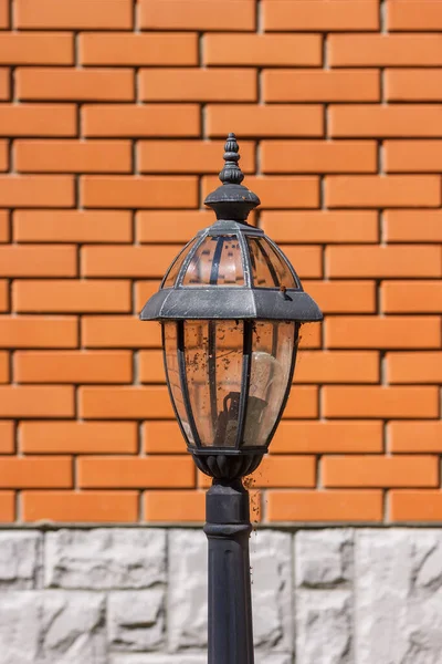 Broken street lamp on a background of a brick orange wall