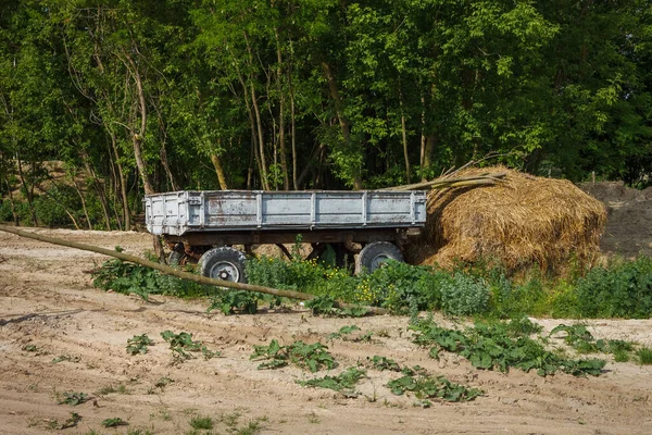 Oude Tractoraanhanger Een Stapel Stro Het Dorpsterrein — Stockfoto