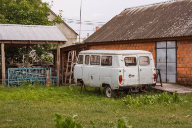 Eski bir Sovyet minibüsü köy bahçesine park edilmiş.