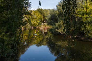 Nehirde kano yapıyorum. Nehir yatağını gören manzara. Fazla gelişmiş kıyılar