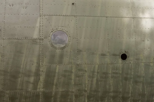 Eski bir uçağın gövdesinin detayları. Askeri bir uçağın eski kamuflaj yüzeyi. 