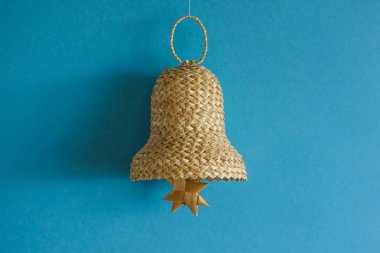 Mavi arka planda samandan yapılmış çan. Hasır çan süslemeleri. Arkaplan