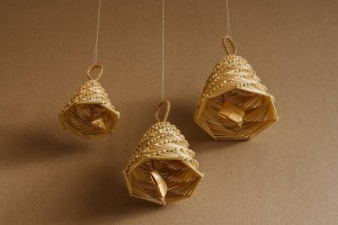 Bej arka planda samandan yapılmış çan. Hasır çan süslemeleri.