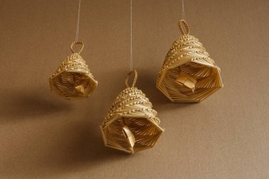 Bej arka planda samandan yapılmış çan. Hasır çan süslemeleri. 