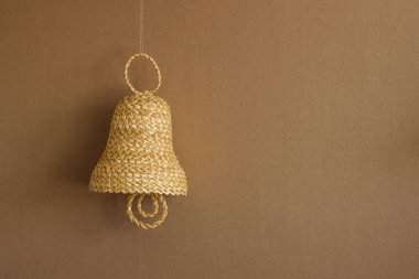 Bej arka planda samandan yapılmış çan. Hasır çan süslemeleri. Uzayı kopyala Arkaplan