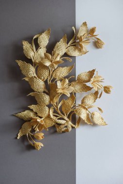 Yapraklı ve çiçekli dal samandan yapılmıştır. Saman duvar dekorasyonu. Ürünler samandan yapılmıştır. Gri beyaz arkaplanda saman süslemesi.