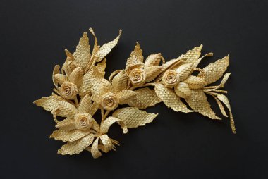 Siyah arka planda saman süslemesi. Yapraklı ve çiçekli dal samandan yapılmıştır. Dekorasyon. Yakın çekim.