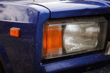 Stara Vyzhivka, Ukrayna - 25 Ağustos 2020: Bir arabanın kirli farları. Yakın plan. Kırsal alanda mavi renkli bir Sovyet arabası park halinde. Vaz 2107