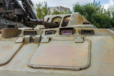 Bir top ve Sovyet zırhlı personel taşıyıcısının makineli tüfeği olan kule. Mavi gökyüzünün arka planında askeri teçhizatın ayrıntıları ve bulutlar. Yakın plan..