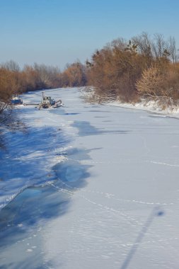 Donmuş kış nehrindeki tekneler. Kış manzarası. Ukrayna.