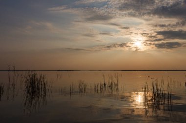 Gölde gün batımı. Güzel bulutlarla dolu akşam gökyüzü gölün suyuna yansıyor.