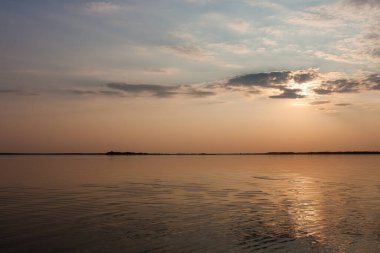 Gölde gün batımı. Güzel bulutlarla dolu akşam gökyüzü gölün suyuna yansıyor.