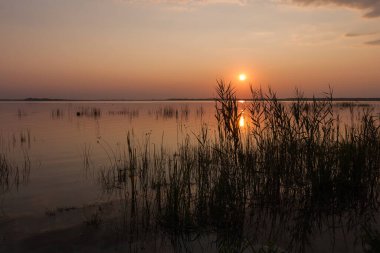 Gölde gün batımı. Güzel bulutlarla dolu akşam gökyüzü gölün suyuna yansıyor.