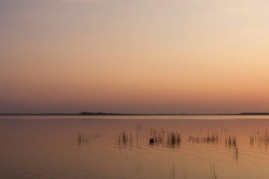 Gölde gün batımı. Güzel bulutlarla dolu akşam gökyüzü gölün suyuna yansıyor.