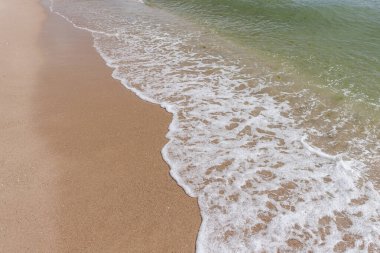 Beyaz köpüklü dalgalar ve kumlu kıyılar