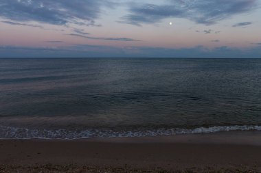 Karadeniz. Güzel bulutlarla akşam gökyüzü ve ay denizin suyuna yansıyor..