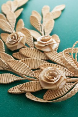 Yeşil arka planda saman süslemesi. Çiçekli dal. Üst Manzara. Samandan örgü örüyorum. Dekor