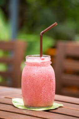 ahşap arka plan üzerinde çilek güler yüzlü bir bardak