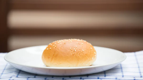 Хлеб с кунжутом на белой тарелке — стоковое фото